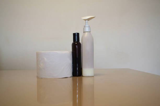 a shampoo and a liquid soap on a table and paper towel