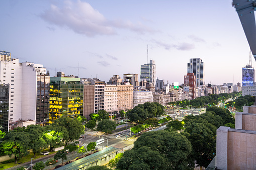Twilight view of Buenos Aires showing illuminated buildings and bustling city life in Argentina's capital.