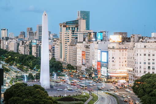 Dusk settles over Buenos Aires, showcasing the Obelisk and city lights in a bustling urban scene.