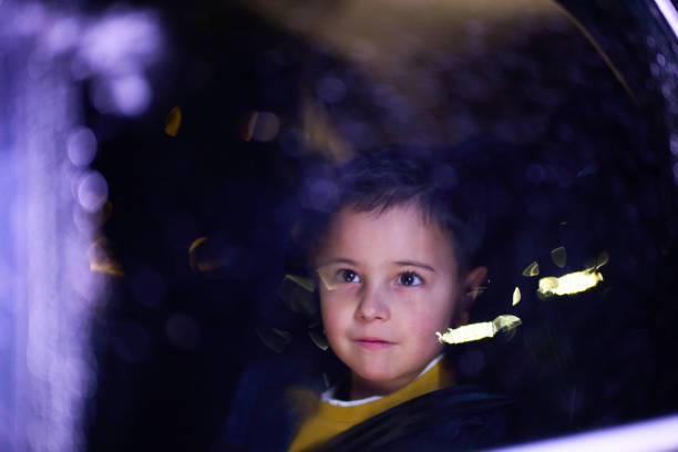 Pensive Caucasian boy looking through a window