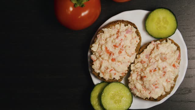 Crab meat salad sandwiches. Crab sticks toasts. Black wooden table. Close up.