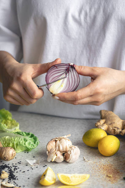 istock A woman cuts onions for salad on the kitchen table, close-up. 2025148734