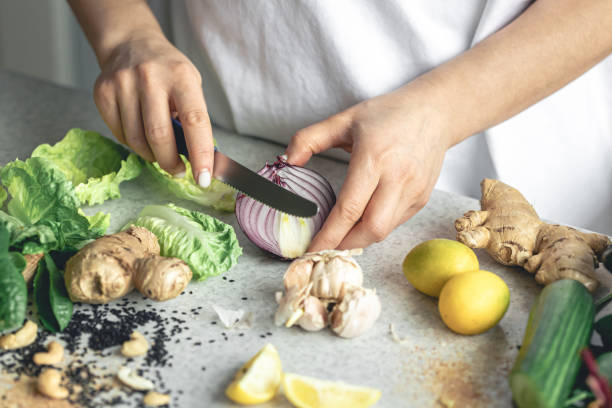 istock A woman cuts onions for salad on the kitchen table, close-up. 2025148736