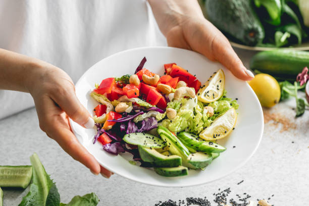istock A plate with chopped fresh vegetables in female hands in the kitchen. 2025150371