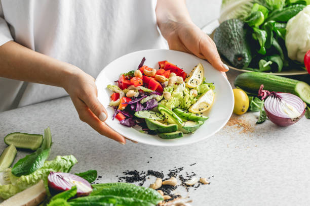 istock A plate with chopped fresh vegetables in female hands in the kitchen. 2025150376