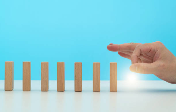 istock Human finger pushing domino pieces 2025249507