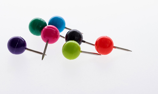 set of pins, color paper clips on a white background, close up view