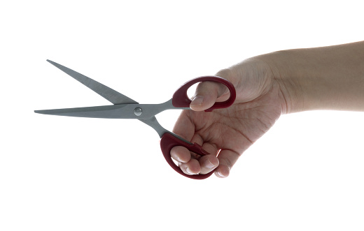 Woman holding a pair of scissors on white background