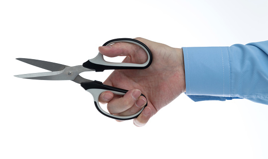 Male hand holding a pair of scissors. Isolated on a white background.