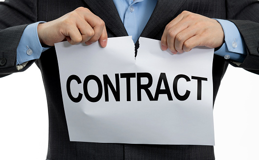 Businessman tearing paper with word contract