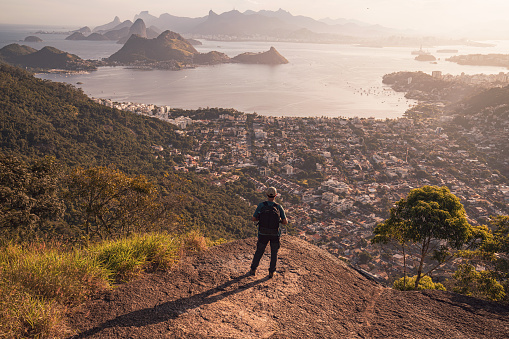 Senior hiker overlooking the panoramic view of the city at sunset