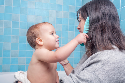 son playing at combing his mother's hair after showering