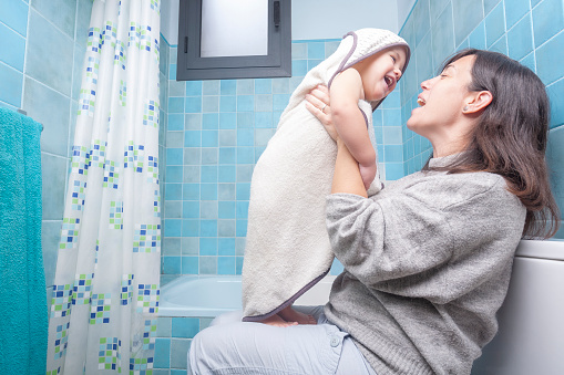 Mother and child in a playful moment after showering
