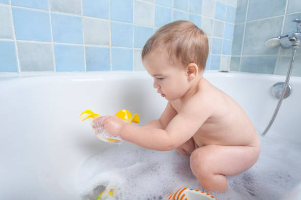 istock toddler playing with rubber ducky in bathtub 2025287816