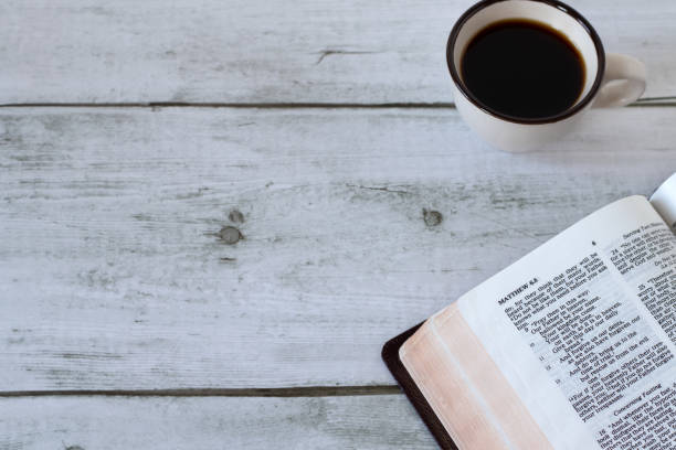 istock Open holy bible book with cup of coffee on rustic wooden table 2025292116