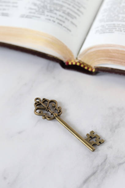 древний ключ с открытой священной библейской книгой - kingdom стоковые фото и изображения