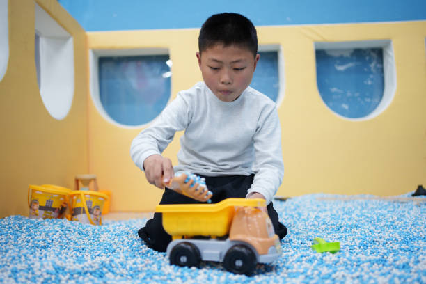 little boy playing with toy car