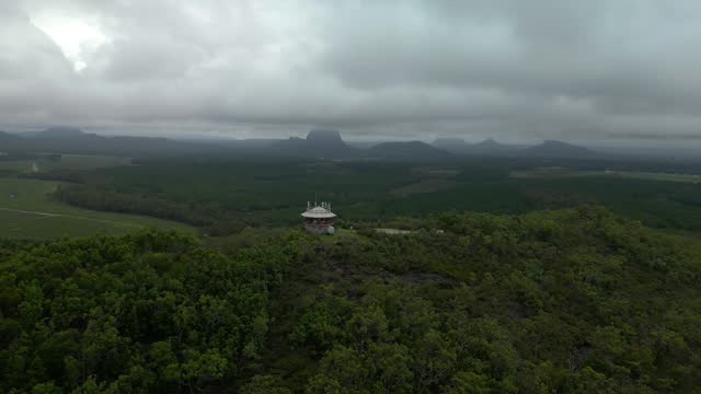 Wild Horse Mountain lookout and fire tower with scenic views of the Glass House Mountain Range. Panoramic drone view