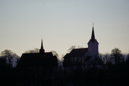 Churches at Kvernes silouetted against a clear sky.
