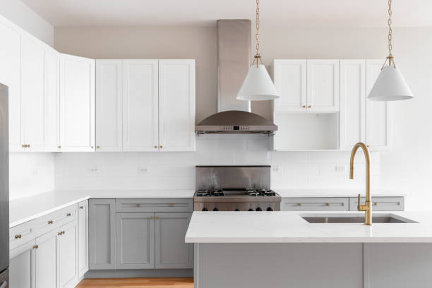 istock A grey and white kitchen with gold faucet and light fixtures. 2025317152