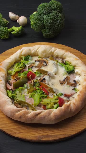 Vertical video. Presentation of pizza on a dark brown table with its ingredients.