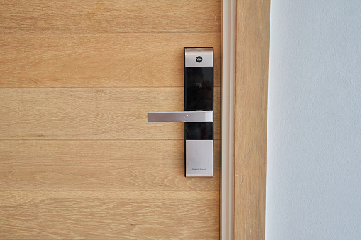 Aluminum manual latch bolt installed on a white lacquered aluminum carpentry door inside a home