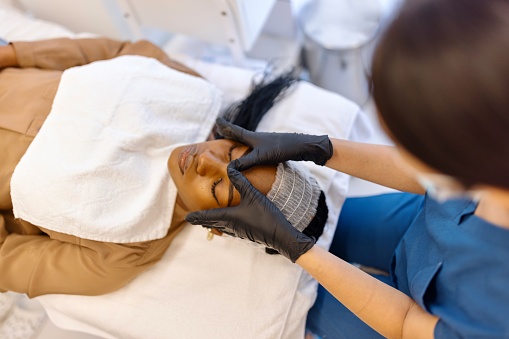 Beautiful black woman doing a facial treatment