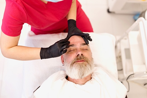 Close-up of a man doing a facial treatment