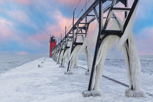 Winter landscape of the South Haven, Michigan lighthouse, pier, and catwalk coated in ice, Lake Michigan, USA