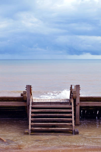 clic vertical del espigón en la playa de bacton, norfolk, con el cielo del mar y el horizonte sobre el agua - horizon over water england uk summer fotografías e imágenes de stock