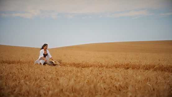 Cheerful Woman Radiates Happiness As She Playfully Rides Her Bicycle Through A Wheat Field. With Each Carefree Pedal, She Weaves Through The Vast Expanse, Capturing The Simple Pleasures Found In The Heart Of Nature.