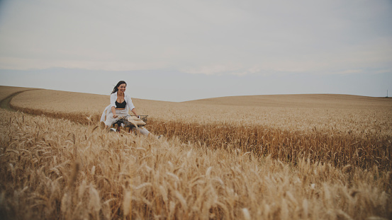 Delighted Woman Happily Rides Her Bicycle Through A Golden Wheat Field, Soaking In The Sheer Joy Of The Moment
