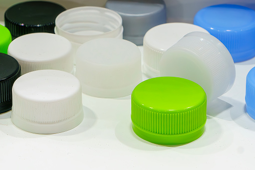 The group of green and white plastic drinking water caps. The plastic caps manufacturing concept.