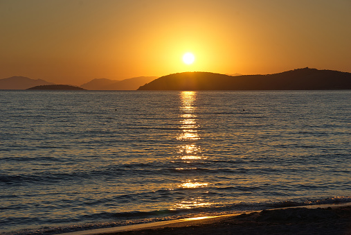 sea ​​view of Drepanon beach at sunset against the sky and coast of Corfu