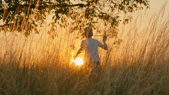 Boy's Silhouette With A Toy Airplane,Set Against The Golden Sunset In A Wheat Field.