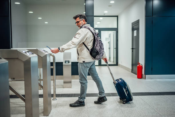 istock Mature man passing through turnstile at train station 2025400020