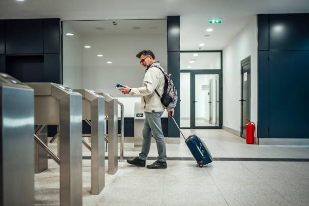 istock Mature man passing through turnstile at train station 2025400546