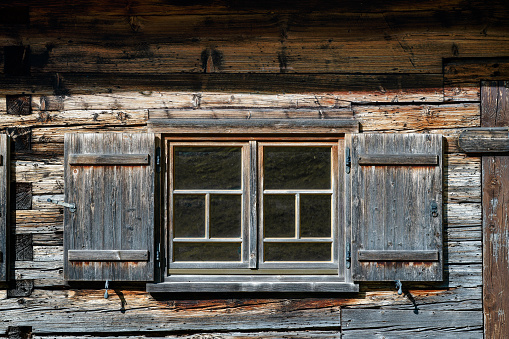 An old wooden window of a cabin log in Bavaria (Germany) near Munich.