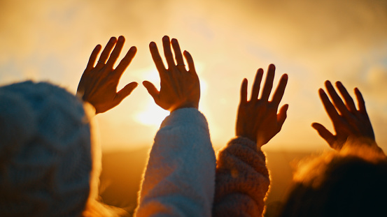 In A Captivating Moment During Sunset,A Cropped Image Captures Young Female Friends Extending Their Palms Towards The Sky. Their Silhouettes Against The Vibrant Hues Of The Setting Sun Evoke A Sense Of Wonder And Connection With The Beauty Of Nature,As They Embrace The Magic Of The Golden Hour Together