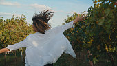 Joyful Woman with Outstretched Arms in Vineyard