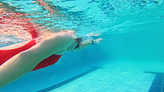 Female Swimmer Honing Her Skills,Her Movements Graceful as She Striving to Improve Her Technique and Become More Proficient in the Water in a Tranquil Resort Pool.