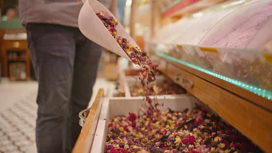 In the Heart of the Grand Bazaar in Istanbul,Turkey,the Midsection of the Shop Owner is Captured as he Skillfully Pours Fragrant Fruit and Herbal Tea into a Container. The Scene Exudes the Essence of Turkish Hospitality and the Rich Tapestry of Flavors Found within the Bustling Marketplace