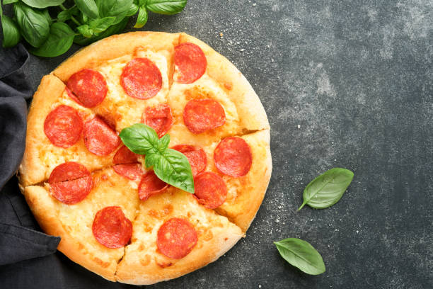 istock Pepperoni pizza. Traditional pepperoni pizza and cooking ingredients tomatoes basil on old concrete texture background table. Italian Traditional food. Top view. Mock up. 2025424497