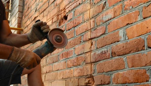 istock male hands with a grinder ready to cut a brick wall 2025429243