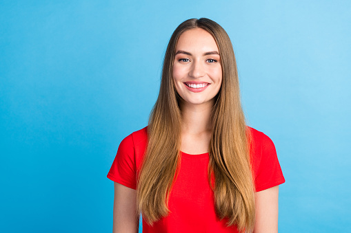 Photo of cheerful glad girl wear red clothes stand empty space isolated on blue color background.