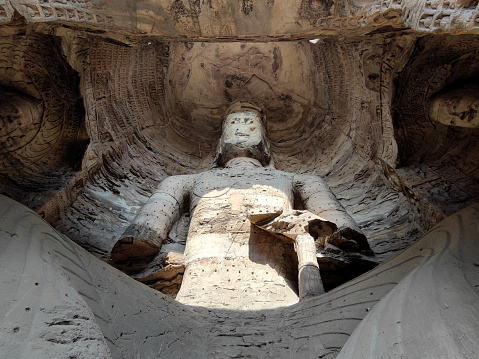 Colossal 15.6 m seated Maitreya Buddha in Cave 17 at Yungang Grottoes, ancient Chinese Buddhist temple grottoes built during the Northern Wei dynasty near the city of Datong, in the province of Shanxi. They are excellent examples of rock-cut architecture and one of the three most famous ancient Buddhist sculptural sites of China. The others are Longmen and Mogao.
