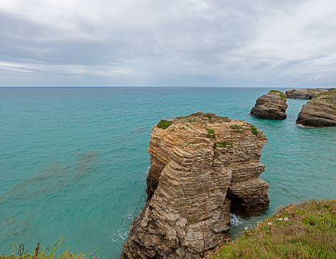 Giant rocks on Las Catedrales beach, with cloudy sky during the day, Lugo, Spain