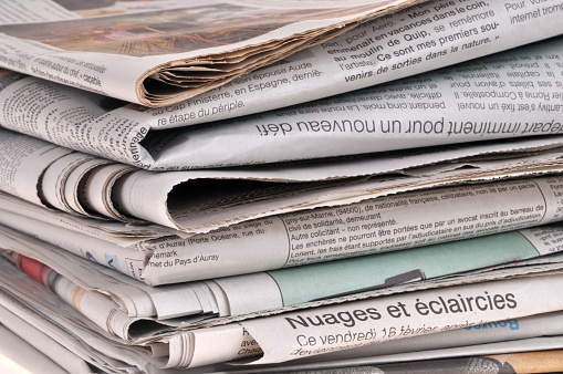 French language newspapers stacked close-up