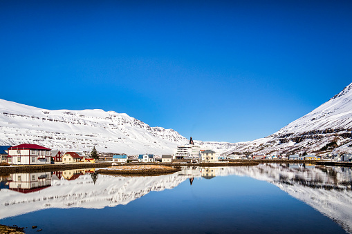 11 April 2018; Seydisfjordur, East Iceland - The village reflectied in the fiord, and the Smyril Line ferry MS Norrona.