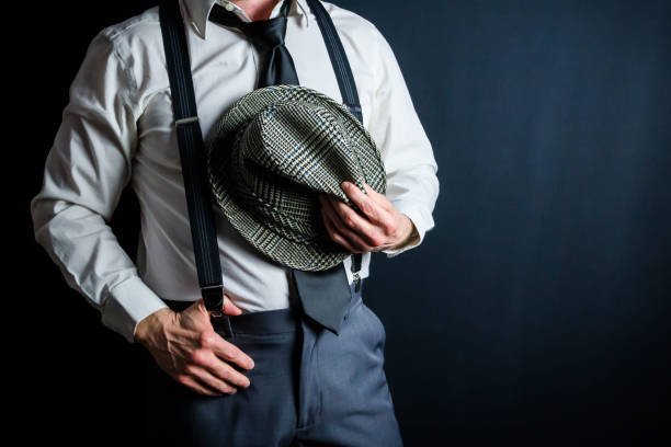 istock Man in Suspenders Holding Fedora Hat 2025445867